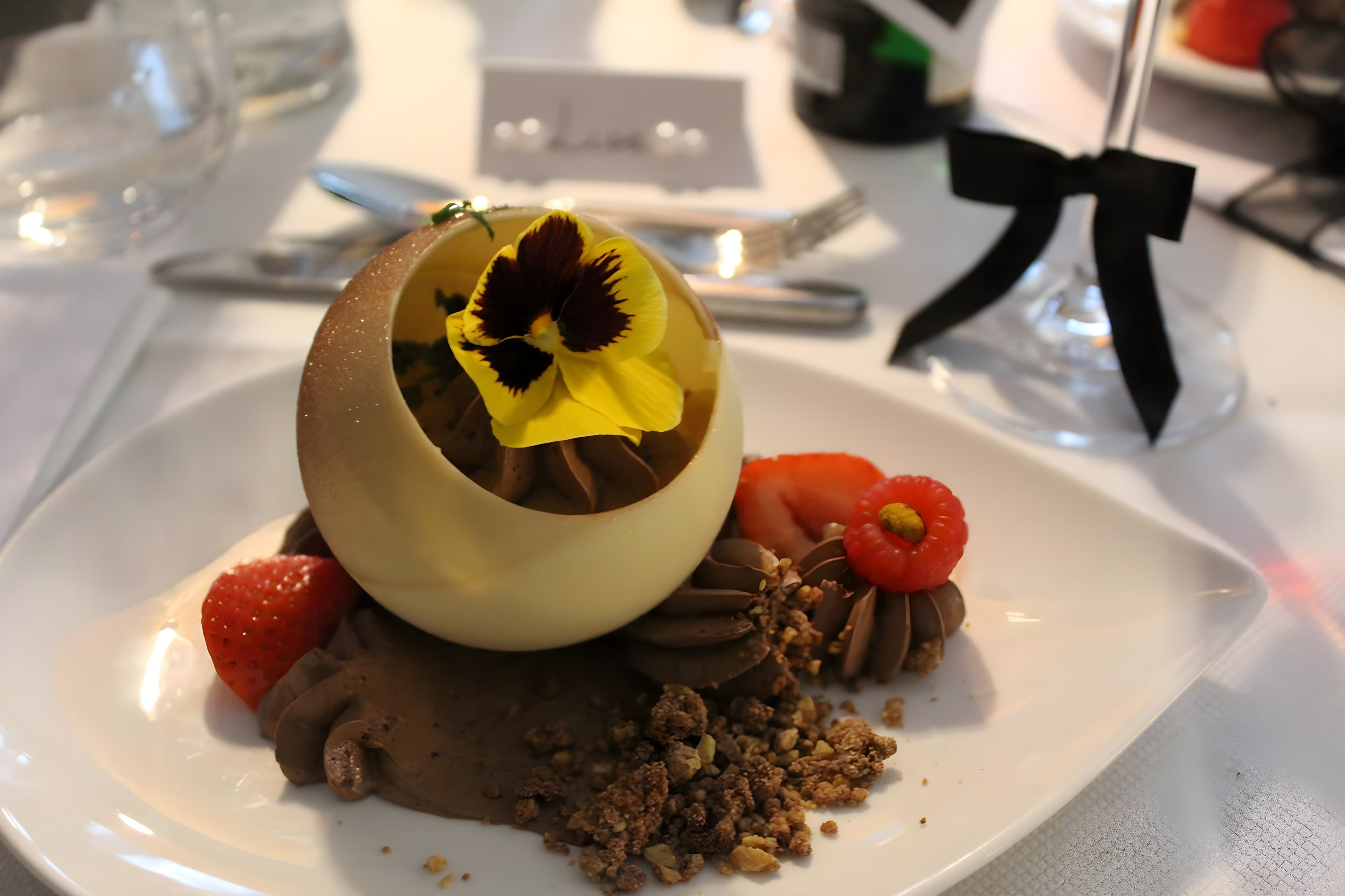 Verfijnd dessert met chocolade, rood fruit en eetbare bloem
